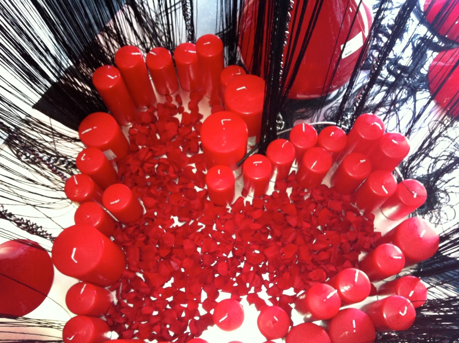 decorazione con candele rosse e petali rossi a forma di cuore 